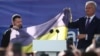 Президент України Володимир Зеленський і президент Литви Гітанас Науседа на площі у Вільнюсі тримають прапор України, який привезли з Бахмута, під час акції на підтримку України у перший день саміту НАТО. Литва. 11 липня. 2023 року