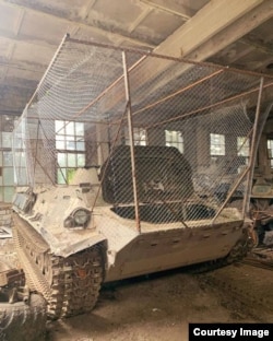 An unidentified armored vehicle with wire mesh, apparently to protect against loitering munitions.