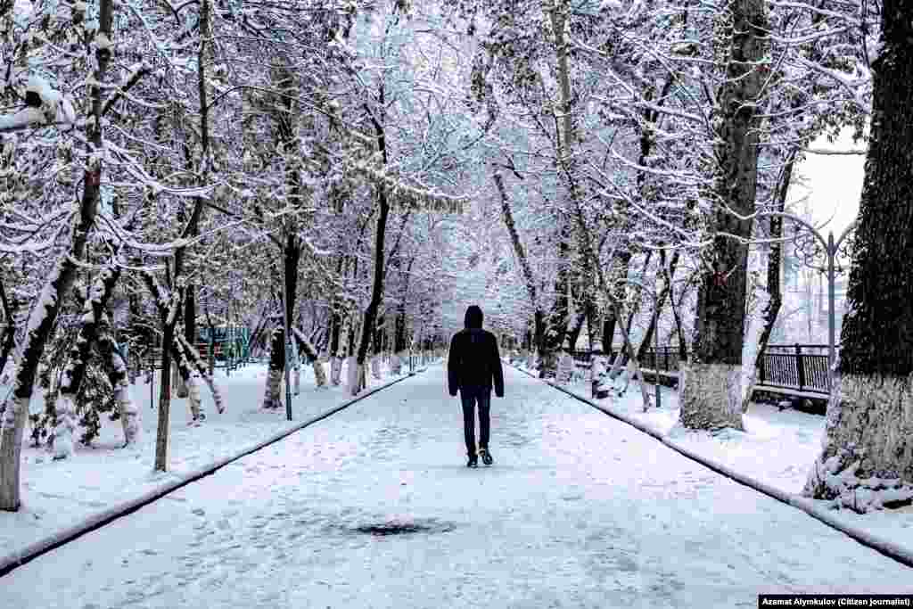 A man walks on a snow-covered path in Osh, Kyrgyzstan.