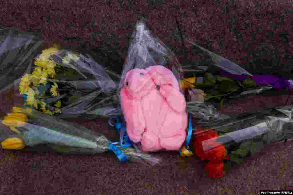 Мягкая игрушка у подножия памятника как дань памяти погибшим в Украине детям