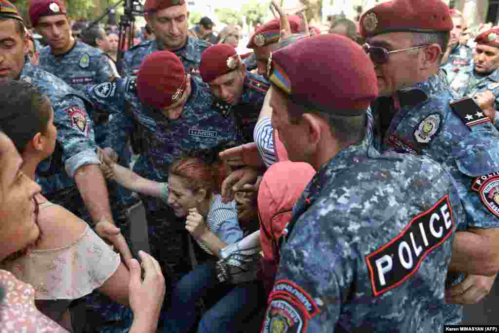 Ofițeri de poliție rețin un manifestant în timpul protestelor antiguvernamentale din Erevan, la 22 septembrie.