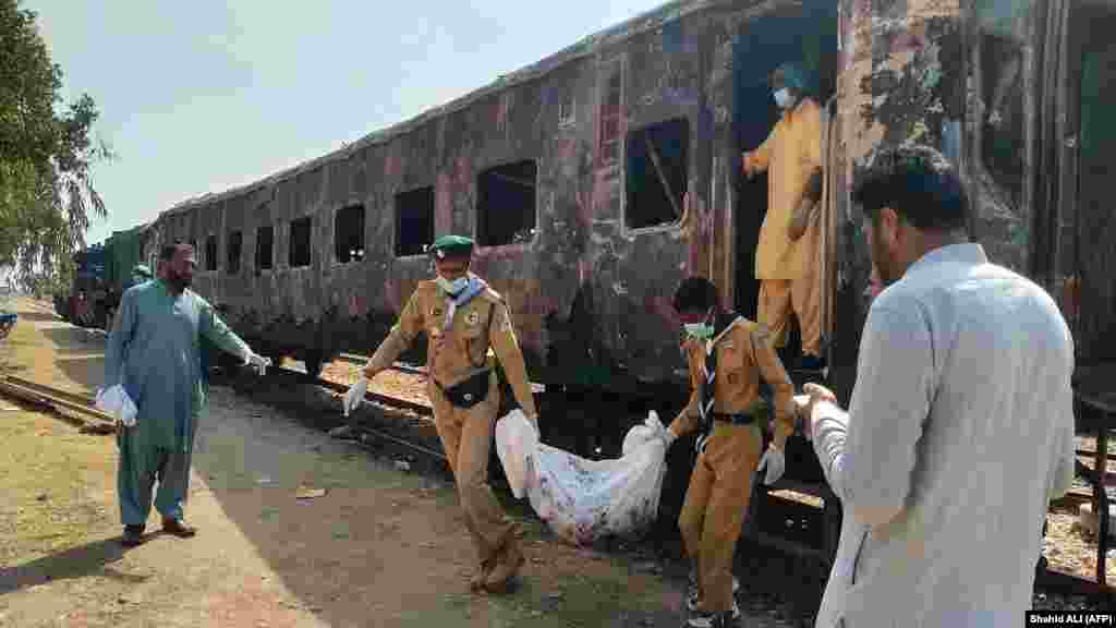 Uklanjanje posmrtnih ostataka žrtve požara u vagonu putničkog voza Karači ekspresa u blizini Sukura, nekih 450 kilometara severno od lučkog grada Karačija 27. aprila. Najmanje sedam osoba je poginulo. &nbsp;