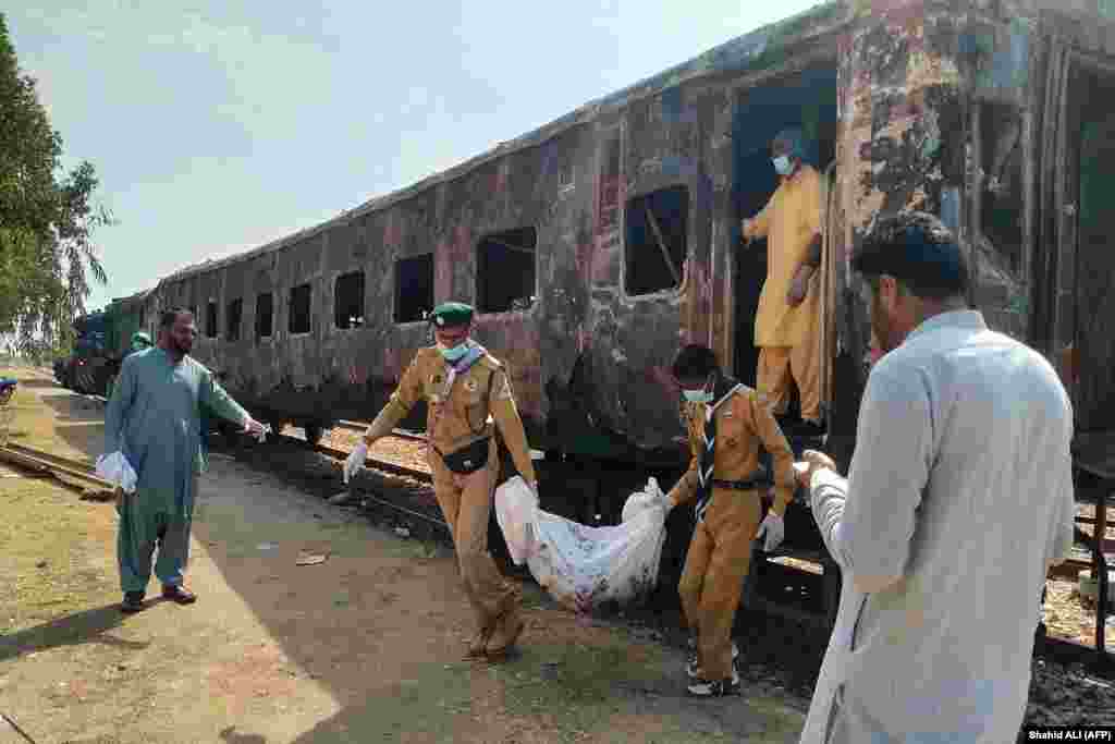 The remains of a victim are removed following an overnight fire in a carriage of the Karachi Express passenger train near Sukkur, some 450 kilometers north of the port city of Karachi on April 27. At least seven people died.