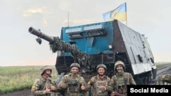 Ukrayna əsgərləri üzərində "Çar manqalı" qurulmuş T-62 tankının - "tısbağa tank"ın qarşısında