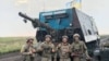 Украинские военные на фоне захваченного российского "танка-черепахи"