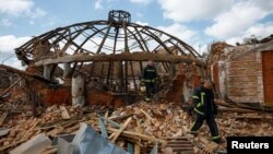 Firefighters work at the site of the Kids and Youth Sport Riding School damaged by Russian missile strikes in the village of Mala Danylivka, outside Kharkiv, Ukraine, on May 30.