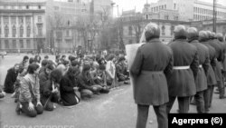 Grup de revoluționari români flancați de scutieri. București, decembrie 1989.