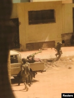 Военная машина-"техничка" и солдаты, предположительно правительственной армии, на улице в Хартуме. Фото из соцсетей. 15 апреля 2023 года
