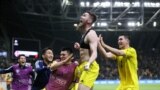 Казахстанец Абат Аимбетов (в центре) празднует победный гол с товарищами по команде, 26 марта 2023 года