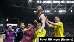 Казахстанец Абат Аимбетов (в центре) празднует победный гол с товарищами по команде, 26 марта 2023 года