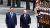 Președintele chinez Xi Jinping (stânga) și președintele rus Vladimir Putin salută garda de onoare în timpul unei ceremonii oficiale de bun venit la Beijing, 16 mai 2024.