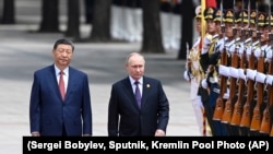 Председатель Китая Си Цзиньпин и президент России Владимир Путин осматривают почетный караул во время официальной церемонии встречи в Пекине, Китай, 16 мая 2024 года