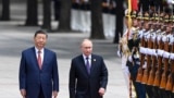Chinese President Xi Jinpin (left) and Russian President Vladimir Putin as they review an honor guard during a visit to Beijing by the Russian leader last year. (file photo) 