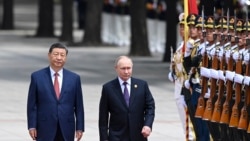 Chinese President Xi Jinpin (left) and Russian President Vladimir Putin as they review an honor guard during a visit to Beijing by the Russian leader last year. (file photo) 