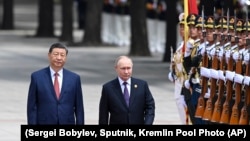 Chinese President Xi Jinpin (left) and Russian President Vladimir Putin as they review an honor guard during a visit to Beijing by the Russian leader last year. (file photo) 