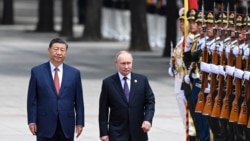 Chinese President Xi Jinpin (left) and Russian President Vladimir Putin review an honor guard during an official welcome ceremony in Beijing on May 16.