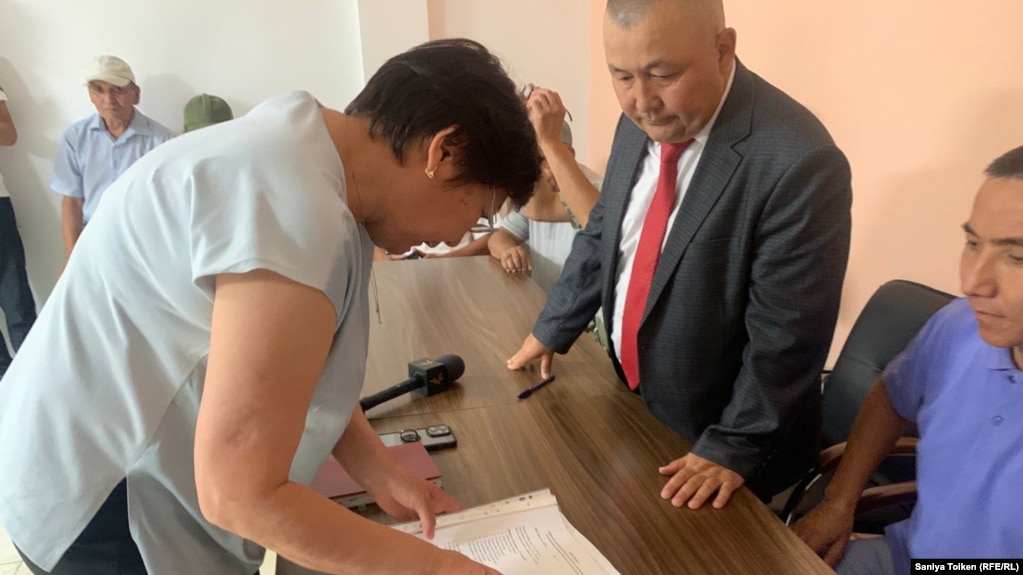 Представитель министерства юстиции принимает документы у активистов инициативной группы по созданию партии «Атажурт». Астана, 9 августа 2023 года