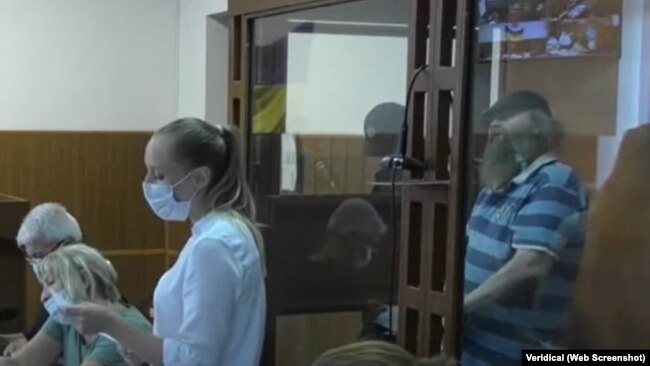 Ihar Klyavko (nella foto con la barba, dietro il vetro della gabbia) ha dichiarato in ogni udienza del tribunale la sua innocenza e la sua detenzione illegale. Ecco come appariva nel luglio 2021