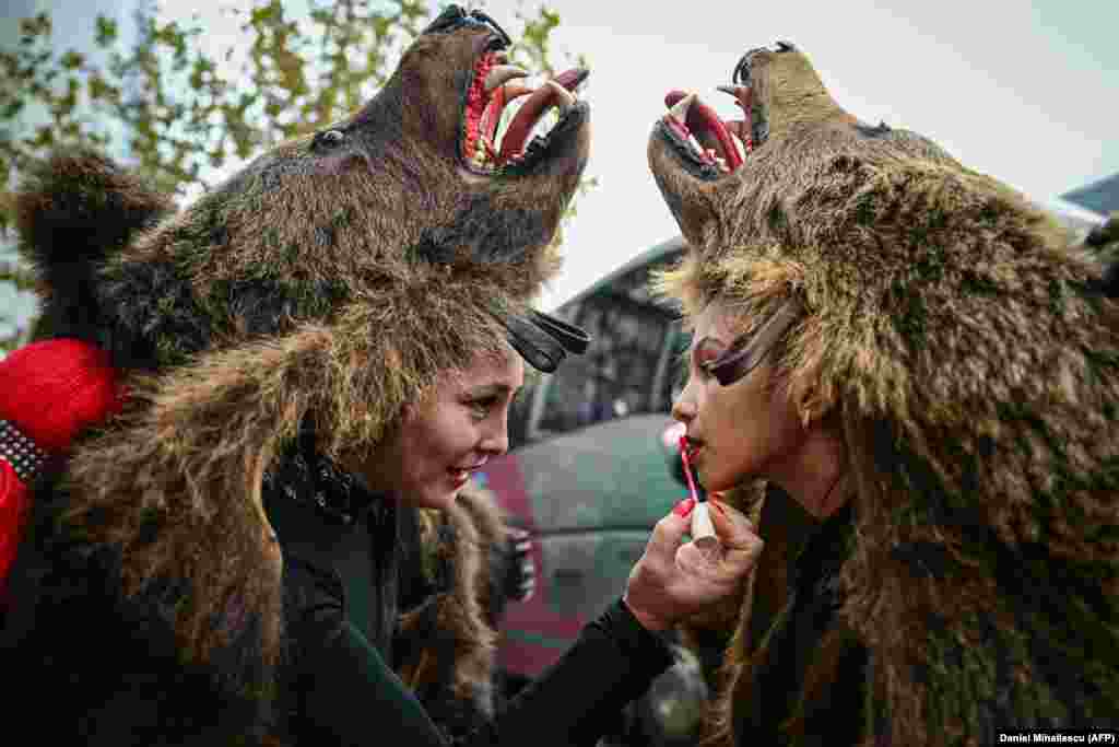 Women wearing bear costumes prepare their makeup just before the opening of Romania&#39;s second annual International Festival of Winter Traditions on December 16.&nbsp;