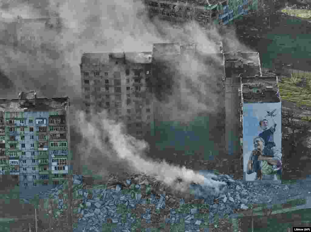 Fumul se ridică din blocurile în flăcări din Bahmut, pe 26 aprilie. În ciuda faptului că rușii folosesc tot mai intens artileria grele și atacurile aeriene, forțele Kievului continuă să împiedice armata rusă să preia controlul total al orașului în ruină.
