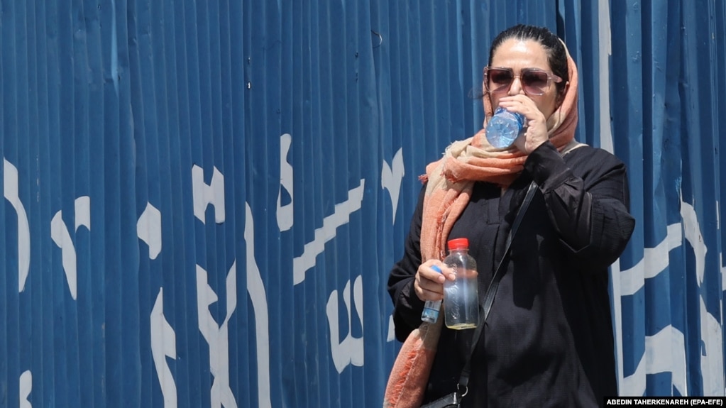 An Iranian woman drinks water during hot weather in Tehran, Iran, 22 July 2024.