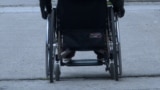 Woman in wheelchair, person with disabilities, moving through streets, Sarajevo, June 2023.