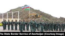 Azerbaijan’s State Border Service raised the country’s national flag near a newly installed checkpoint at the Hakari river bridge marking the entrance to the Lachin Corridor leading to Nagorno-Karabakh from Armenia.