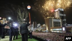 Sjevernokorejski vođa Kim Jong Un (u sredini) maše stanovnicima Pjongjanga na ceremoniji, 17. travnja 2023. 