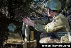 Украинский военнослужащий готовит снаряды к бою