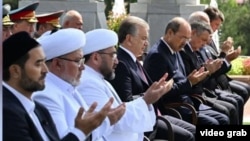 Mufti Nuriddin Kholiqnazarov (from 3rd left to right), President Shavkat Mirziyoev, and Prime Minister Abdulla Aripov pray during a public appearance in Tashkent on August 31.