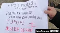 Kirill Voitovich holds a sign in Belarusian commemorating victims of Bolshevik persecution.