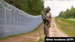 Латвийски граничар патрулира край оградата на границата с Беларус, 8 август 2023 г.