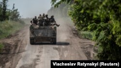 Українські військовослужбовці їдуть на бронетранспортері біля прифронтового міста Бахмут, 9 червня 2023 року

