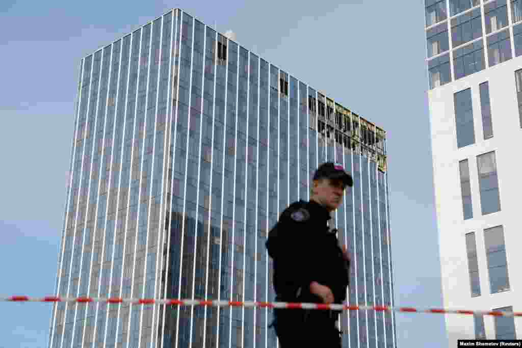 A member of the security services stands guard next to the site of a damaged building in Moscow. The TASS news agency reported one drone crashed in Komsomolsky Prospekt, near the ministry, while another hit a business center on Likhacheva Street by one of Moscow&#39;s main ring roads. &nbsp;