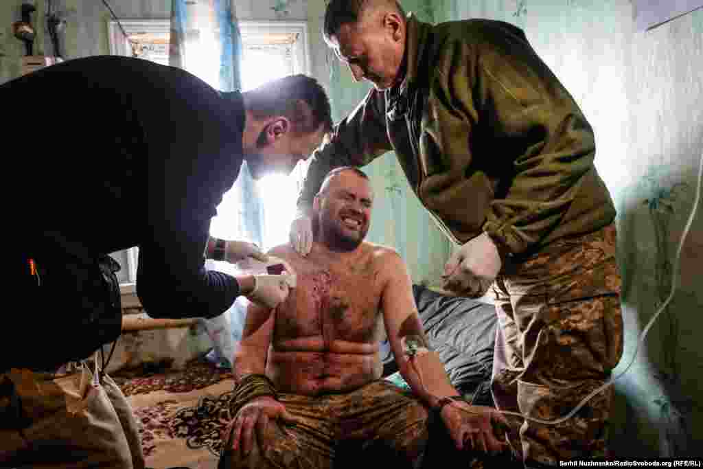 Українські військові медики надають допомогу пораненому бійцю у стабпункті на Соледарському напрямку, березень 2023 року