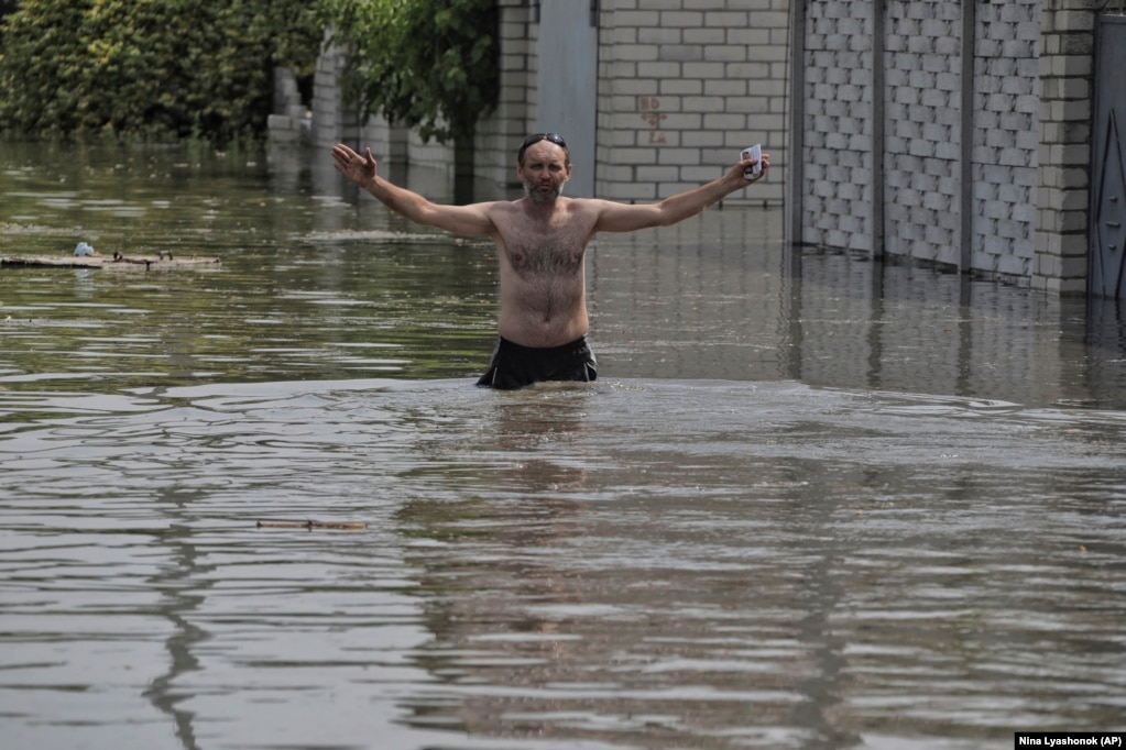 Un localnic traversează puhoiul de ape din Herson. Kievul a acuzat Moscova că a aruncat în aer uriașul baraj din epoca sovietică de pe fluviul Nipru, în ceea ce președintele ucrainean Volodimir Zelenski a numit un act de „terorism”.