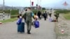 Na ovoj fotografiji preuzetoj sa video snimka koji je objavila pres-služba Ministarstva odbrane Rusije 21. septembra, ruski mirovnjaci pomažu etničkim Jermenima da dođu do kampa u blizini Stepanakerta u Nagorno-Karabahu.