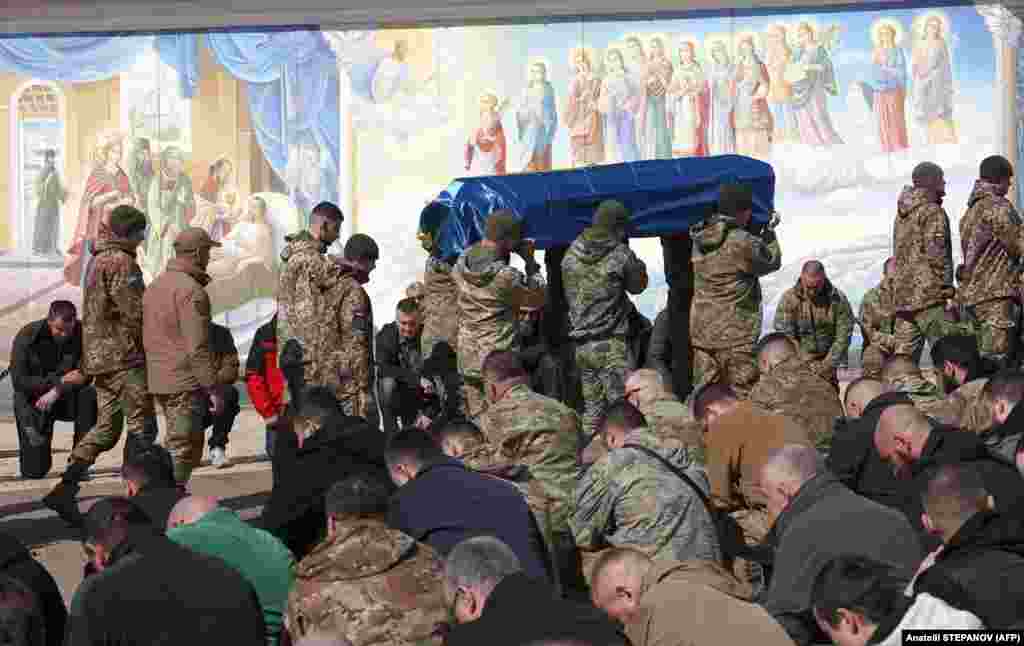 Ukrajinski vojnici nose kovčeg poginulog saborca tokom sahrane u manastiru Svetog Mihaila u Kijevu.