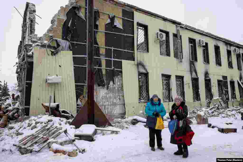 Valentyna Anatolevna and Tetyana Mikhailovna wait to pick up wood to heat their homes outside Lyman&#39;s courthouse. Most of the city&#39;s residents have not returned after fleeing the war. &nbsp;