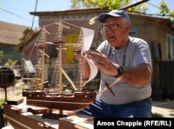 Artamon, a retired Lipovan sailor, builds a model ship in his yard in Sarichioi.