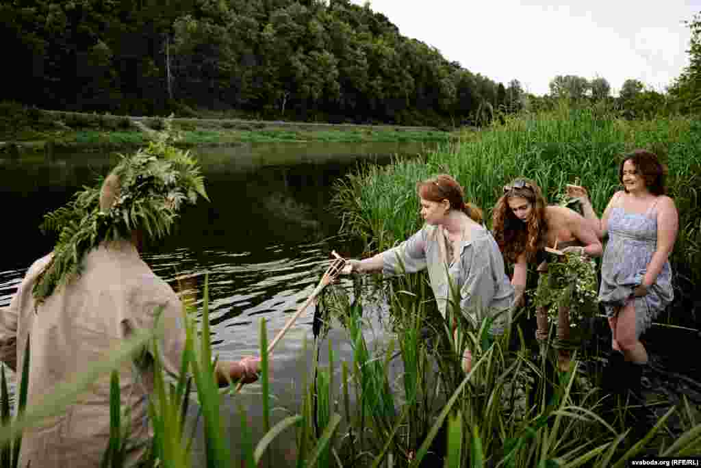 Женщины собираются опустить венки в реку Нерис &nbsp;