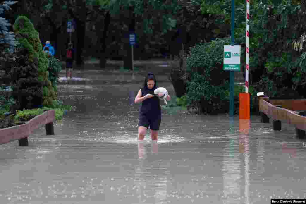 Një grua në qytetin e Kamnikut, Sllovenia veriore, duke ecur nëpër një rrugë të përmbytur nga uji. Agjencia mjedisore e Sllovenisë, ARSO, paralajmëroi në nivelin më të lartë për motin në vend, pasi në 24 orë pati reshje sa për një muaj në pjesët veriore, veriperëndimore dhe qendrore të vendit. &nbsp;