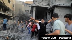 Bărbați palestinieni reacționează în timp ce o fată rănită este salvată din dărâmăturile unei case după ce aceasta a fost lovită de lovituri israeliene, în Khan Younis, în sudul Fâșiei Gaza, 14 octombrie 2023. REUTERS/Yasser Qudih