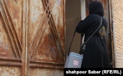 A woman polio worker conducts a door-to-door to vaccination campaign in the western Afghan city of Herat.