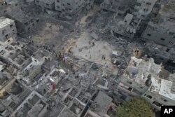 Palestinci hodaju oko zgrada uništenih u izraelskom bombardovanju u izbjegličkom kampu Nuseirat u Pojasu Gaze, 29. oktobra