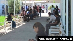 A long line of Turkmen wait outside the offices of the country's Migration Service in the eastern city of Turkmenabat in Lebap Province. (file photo)
