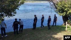 Serbian Police officers search the bank of the Drina River after a boat carrying imigrants sank on the border between Serbia and Bosnia-Herzegovina near the town of Ljubovija on August 22.