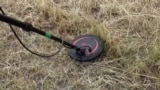 Ukrainian pensioner uses metal detector to sweep her fields for mines - screengrab Reuters