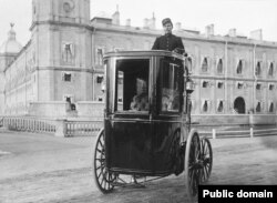 Russian engineer Hippolyte Romanov demonstrates an electric carriage of his own invention outside Gatchina Palace, near St. Petersburg, in the early 1900s.