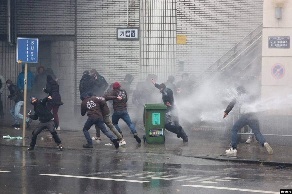 Një person hedh një shishe drej autoriteteve të rendit derisa vrushkujt me ujë spërkatin fermerët protestues në përpjekje për t&#39;i shpërndarë ata, Bruksel, Belgjikë, më 26 shkurt 2024.